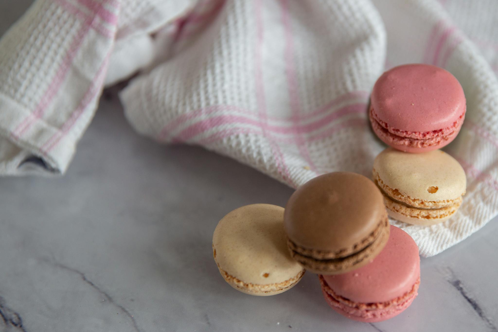 Close-up of colorful macarons with napkin on marble background. Perfect for food blogs.