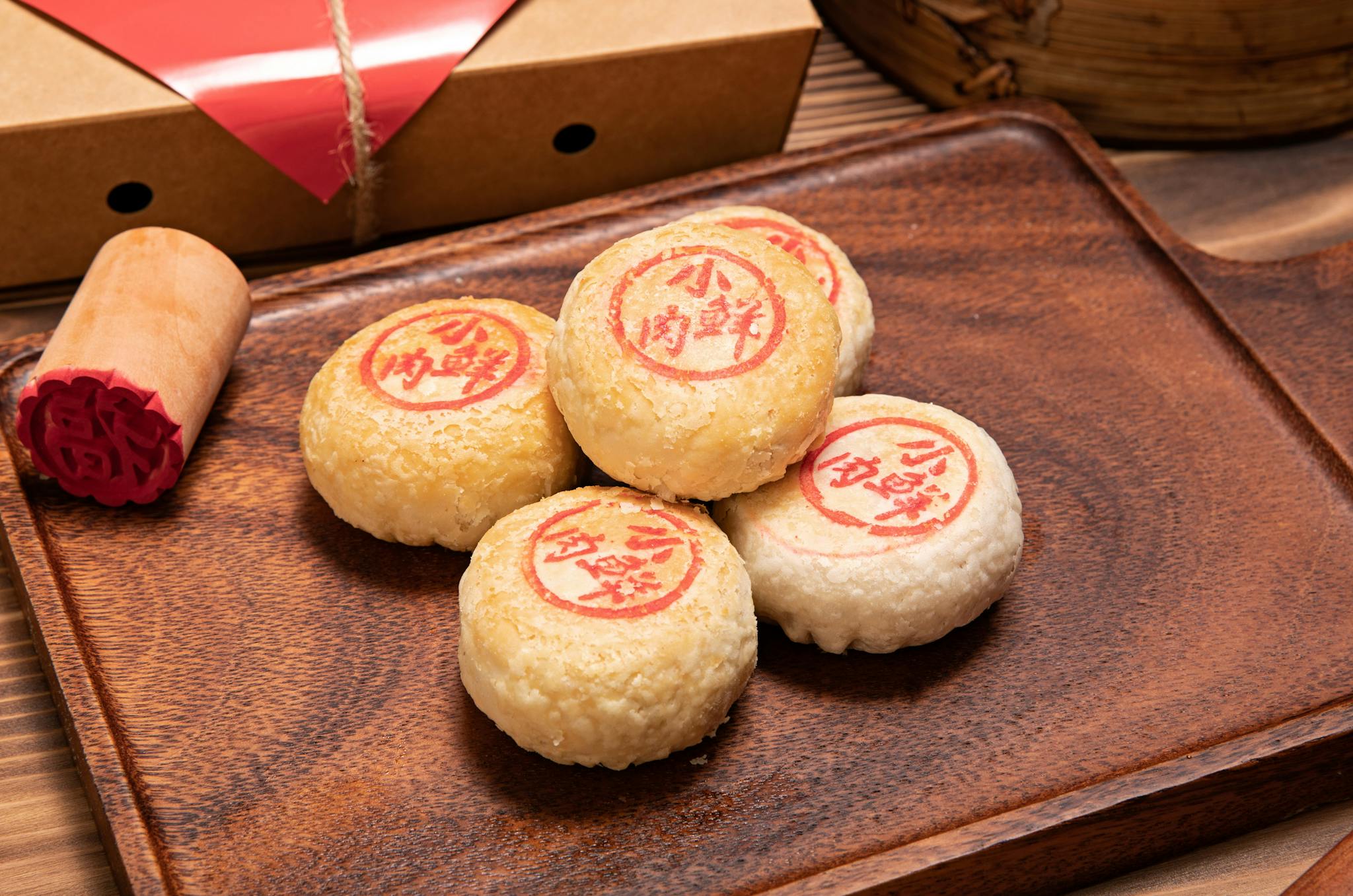Traditional Chinese pastry mooncakes with red stamp served on a wooden tray, symbolizing festivity.